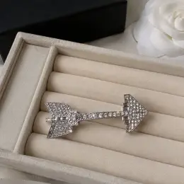 Брошка Chanel зі стразами у формі стріли