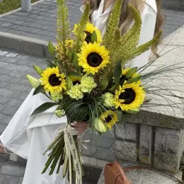 Елегантна святкова композиція з еремурусів, лілій, соняшників та гвоздик